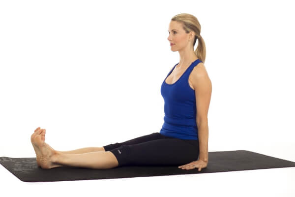 Woman doing an arm extension yoga pose om a green mat Stock Photo - Alamy